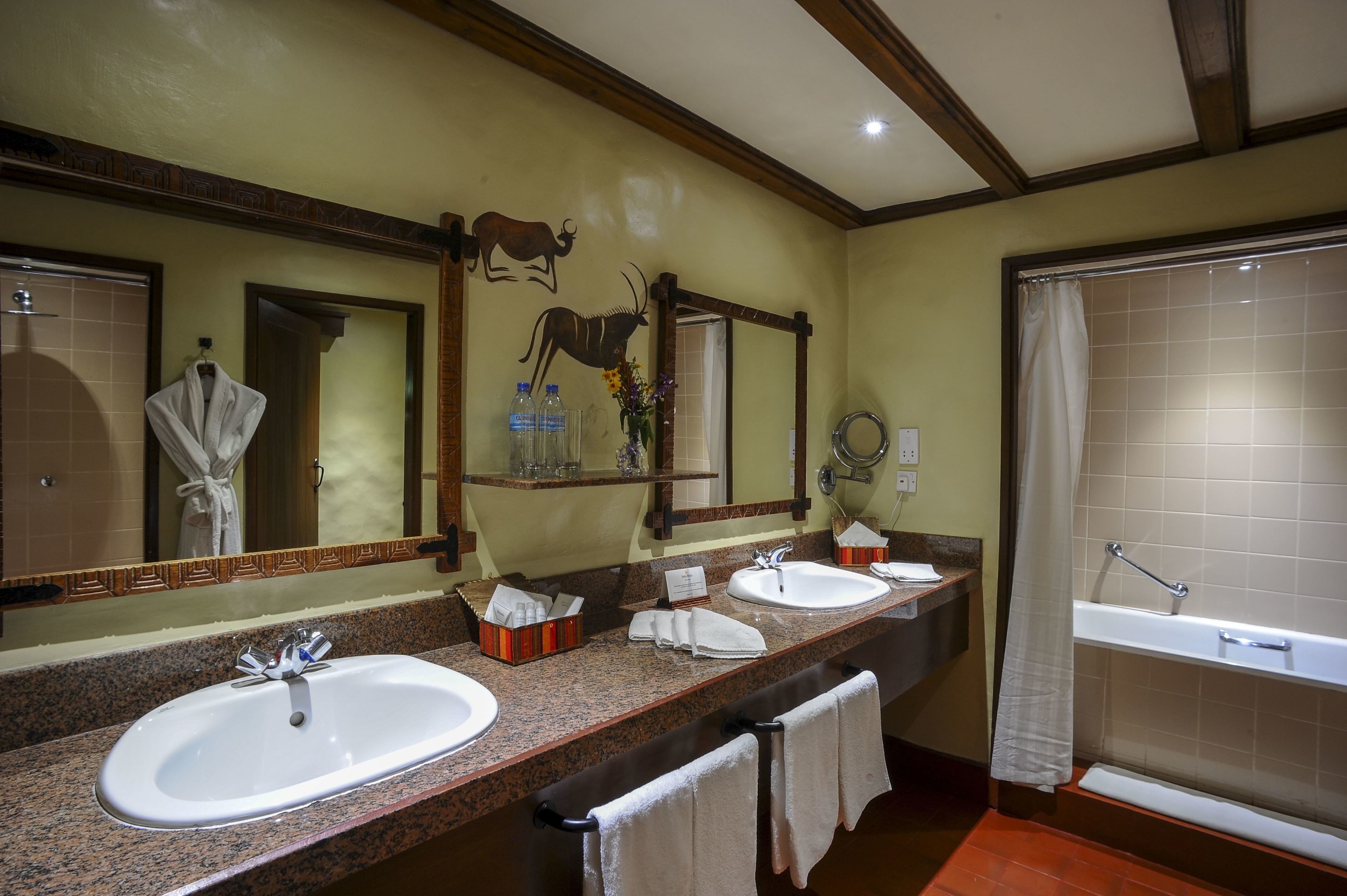 A bathroom with two sinks, a mirror, a towel rack, and a bathtub.