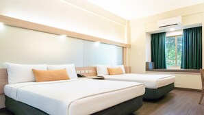 A hotel room with two beds, a window with curtains, an air conditioning unit, and a wooden floor. - Microtel by Wyndham Tarlac (Tarlac)