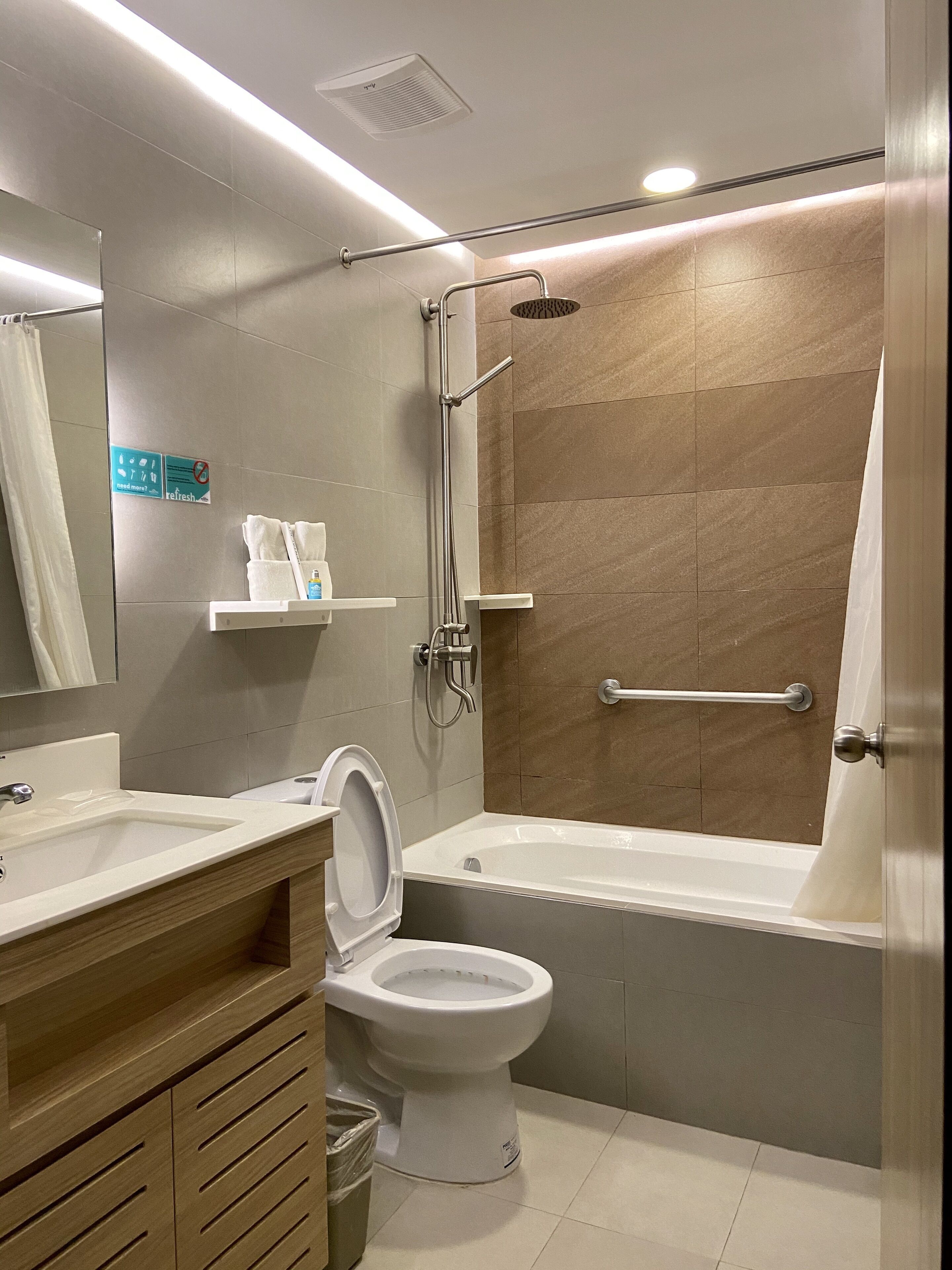 A modern bathroom with a bathtub, toilet, and shower.