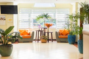 A lobby with two sofas, a coffee table, and potted plants. - Microtel by Wyndham Tarlac (Tarlac)