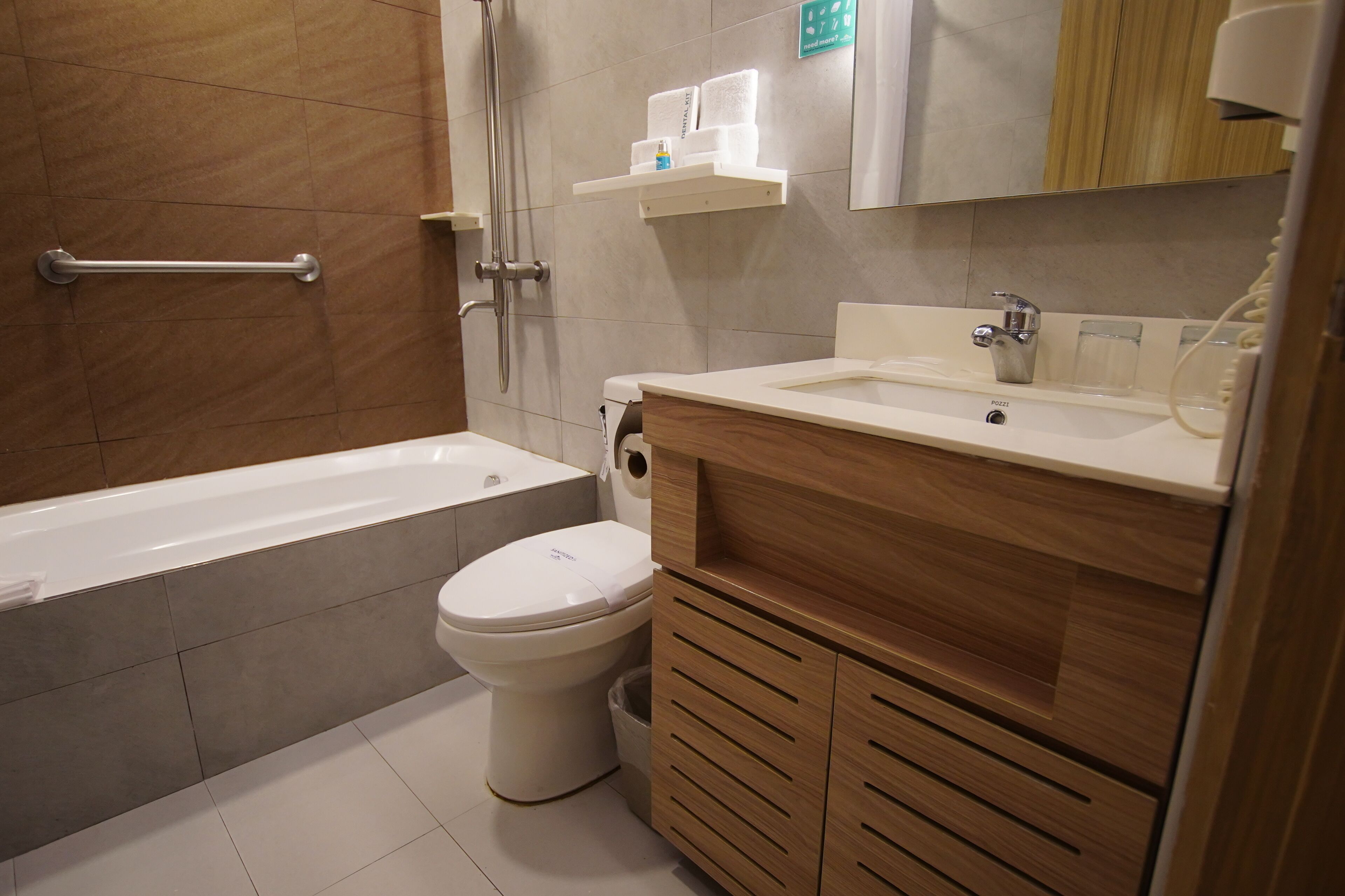 Un baño moderno con bañera, inodoro y tocador de madera.