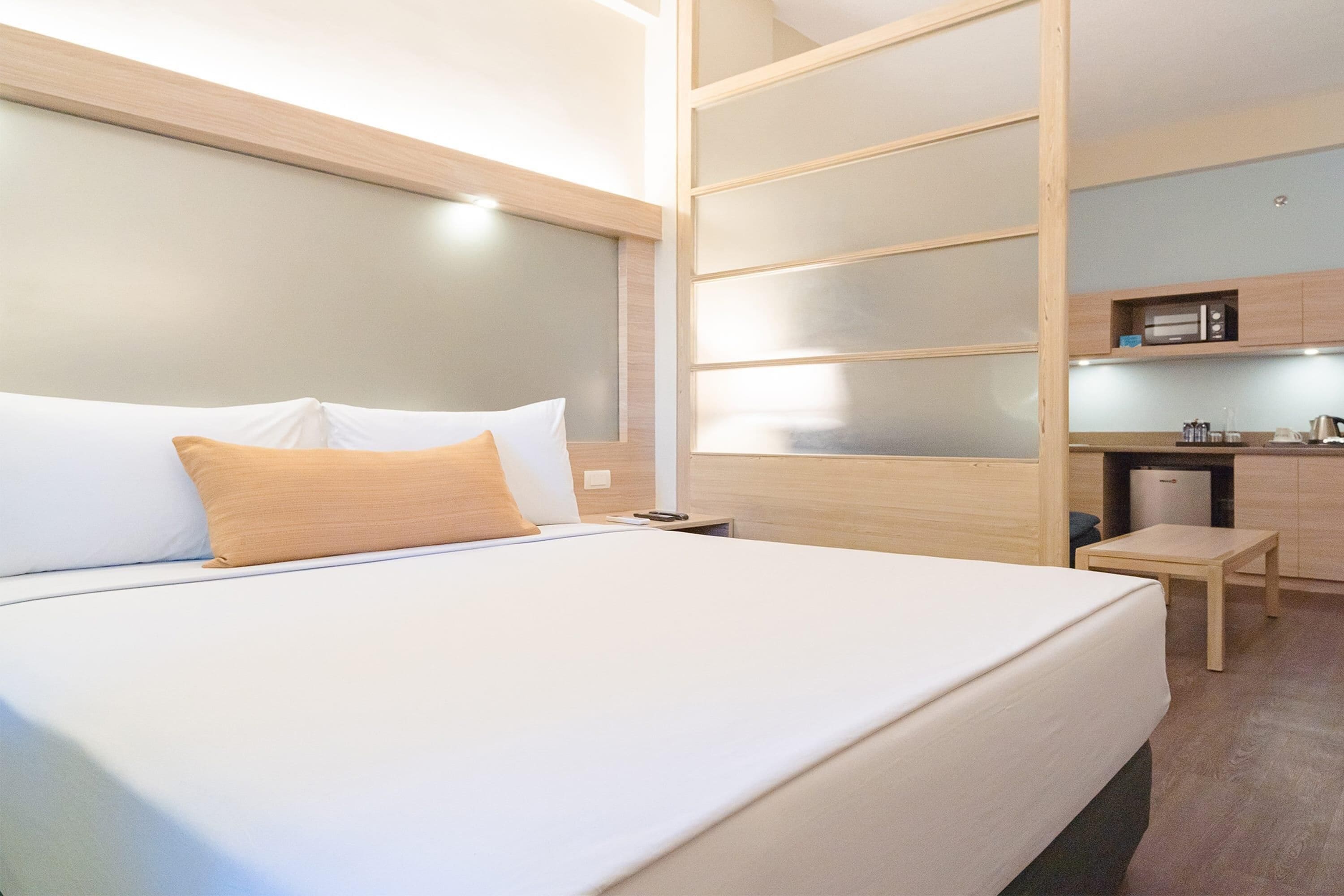 Une chambre d’hôtel équipée d’un lit, d’un bureau et d’un coin cuisine.