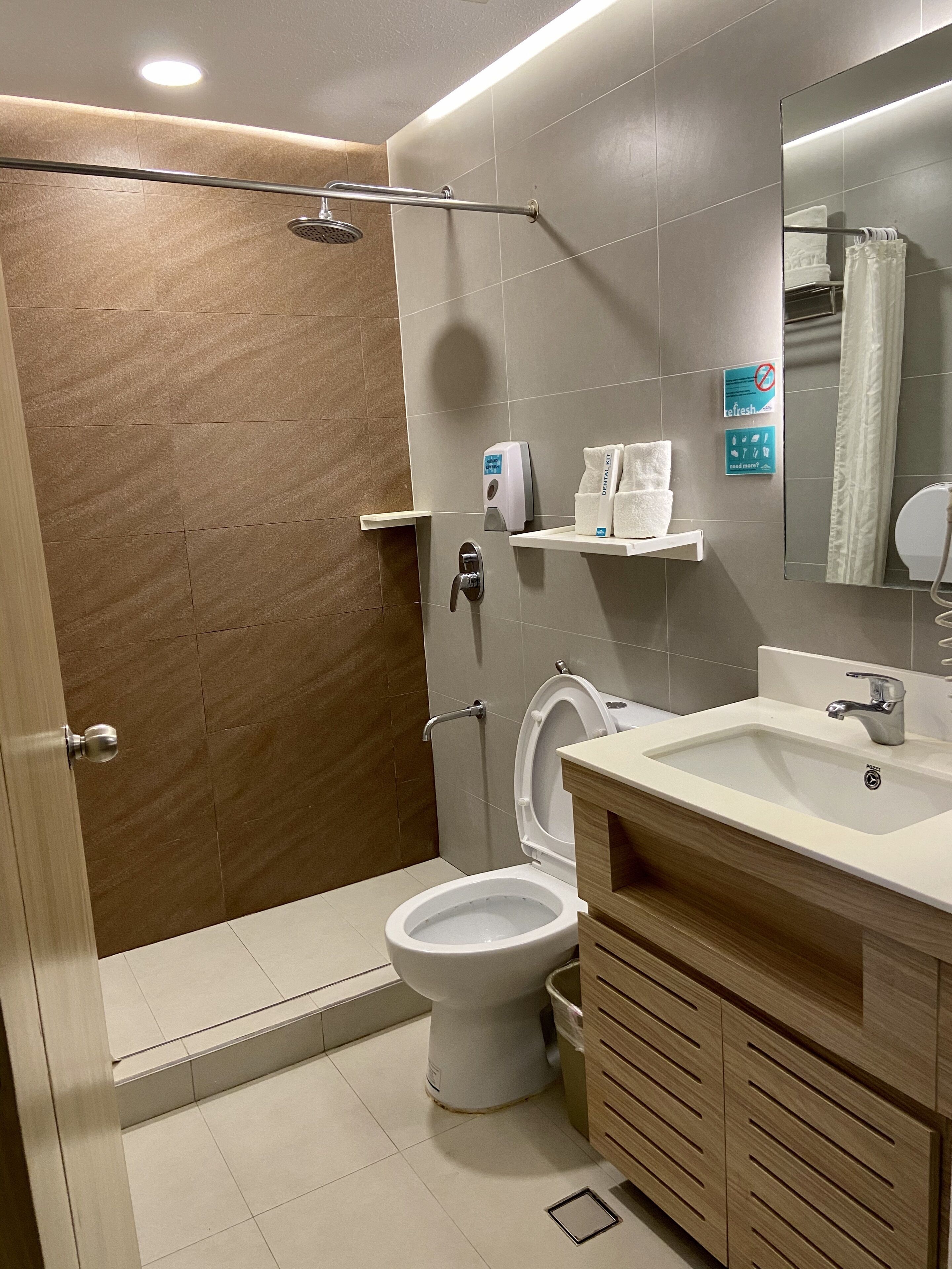 Un baño moderno con ducha, inodoro y lavamanos.