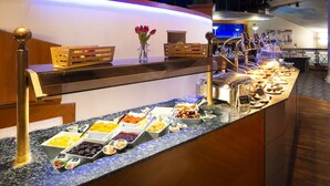 Buffet amb diversos plats i un ram de flors sobre un taulell.