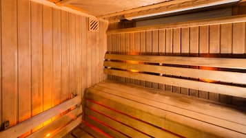 A sauna with wooden benches and a sloped ceiling.