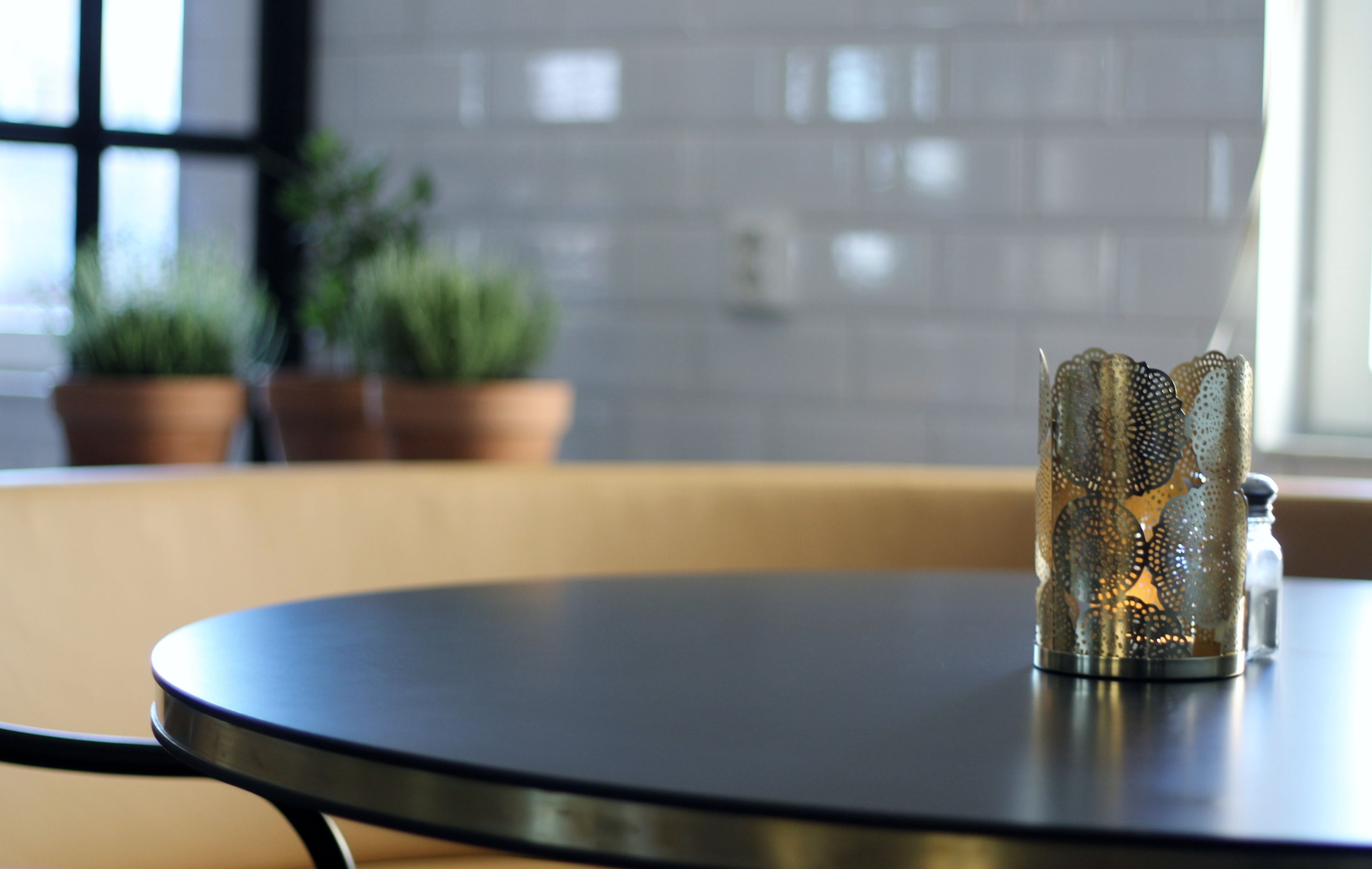 A round table with a metal candle holder in the center.