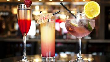 Kolme cocktail-lasia baaritiskillä, tausta on epätarkka.