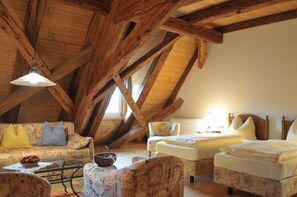Relax in this traditional loft-style room with a comfortable sofa, two single beds, and a small dining area.