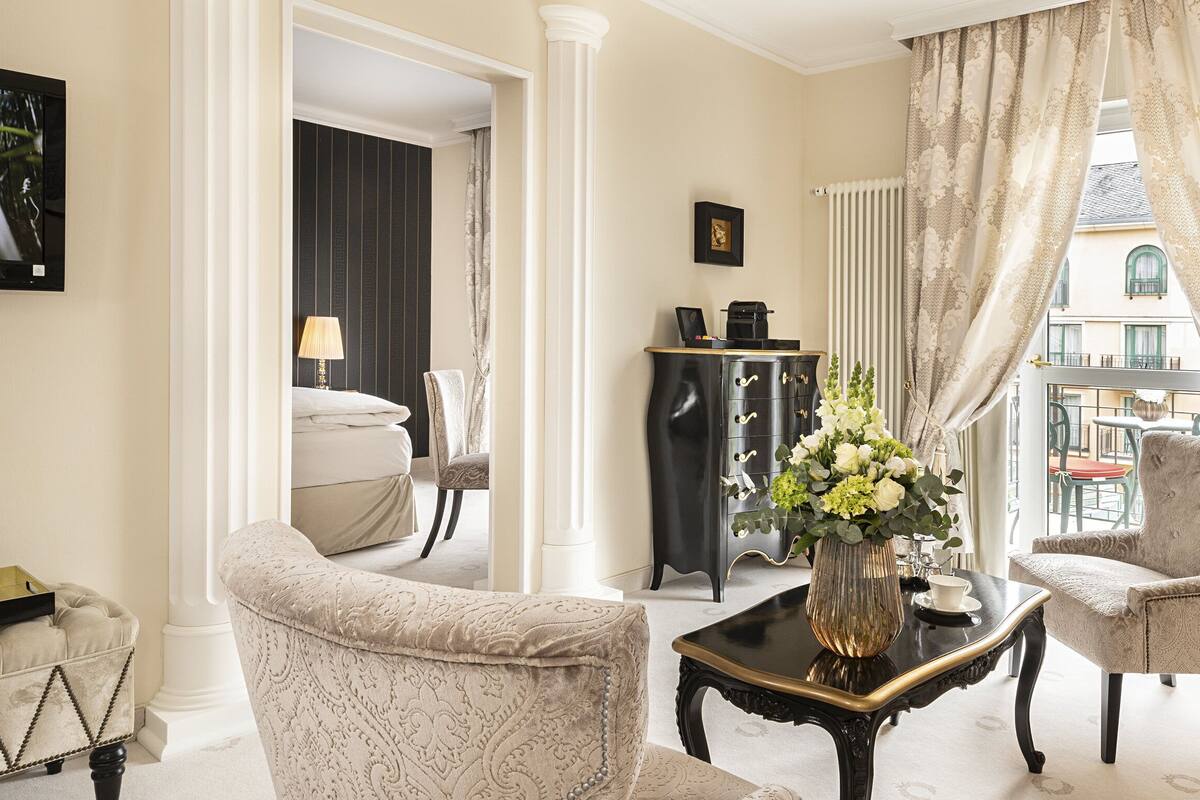 Un salon élégant, doté d’un canapé, de fauteuils, d’une table basse et d’un vase décoratif.