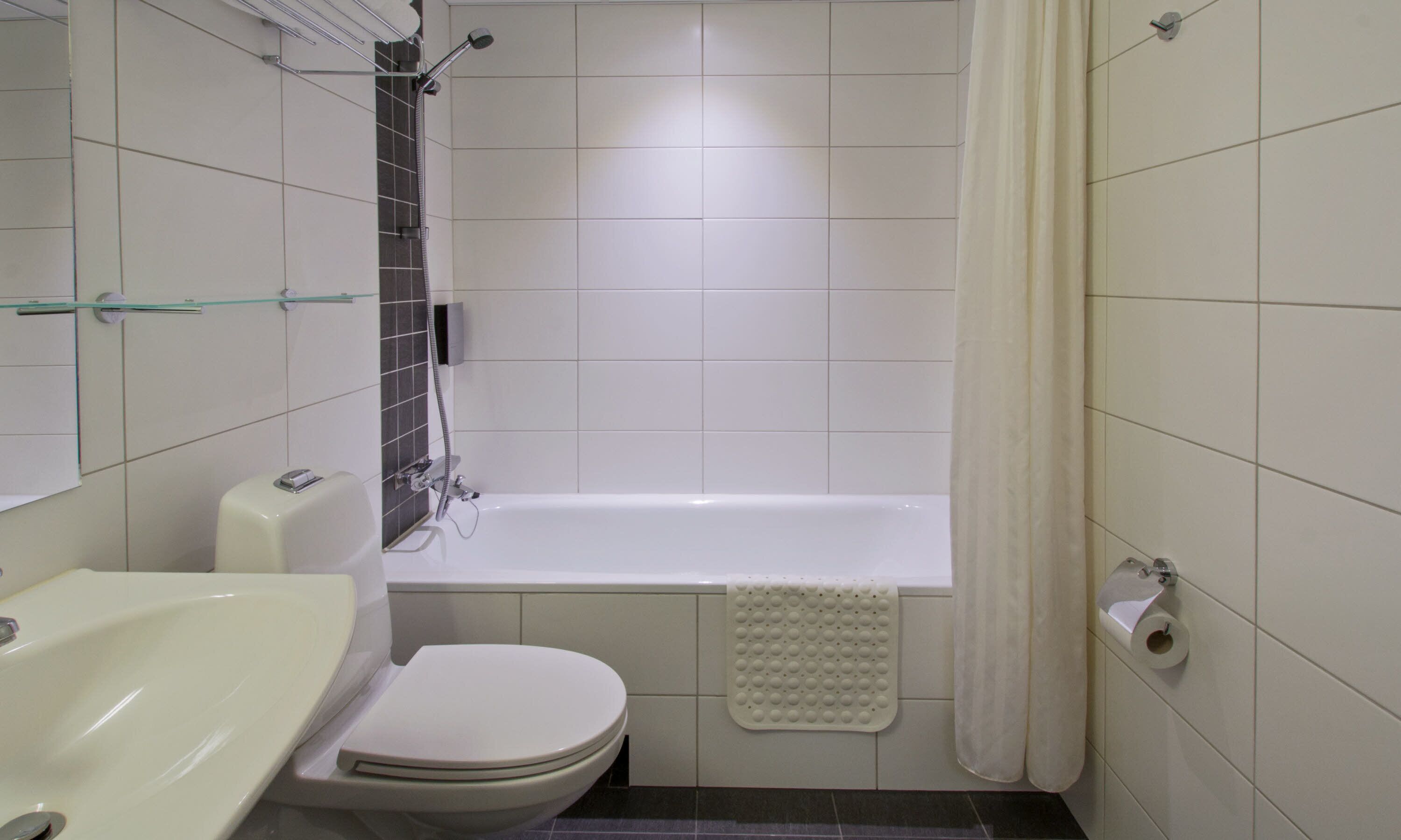 Ein Badezimmer mit einer weißen Badewanne, einer Toilette und einer Duschkabine.