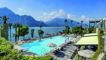 Una piscina techada, una piscina al aire libre, sombrillas