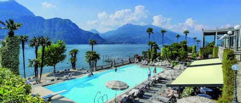 Una piscina techada, una piscina al aire libre, sombrillas