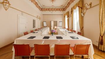 A conference room with a long table, chairs, and a white tablecloth.