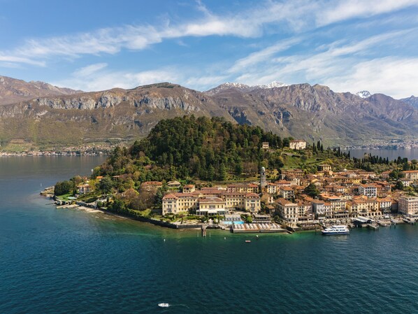 A coastal town with buildings, a lake, and mountains in the background.