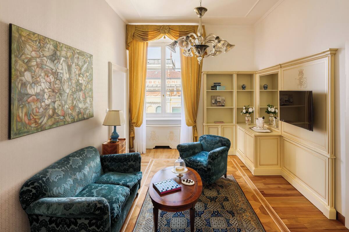 Un salon comprenant un canapé, un fauteuil, une table basse et un téléviseur.