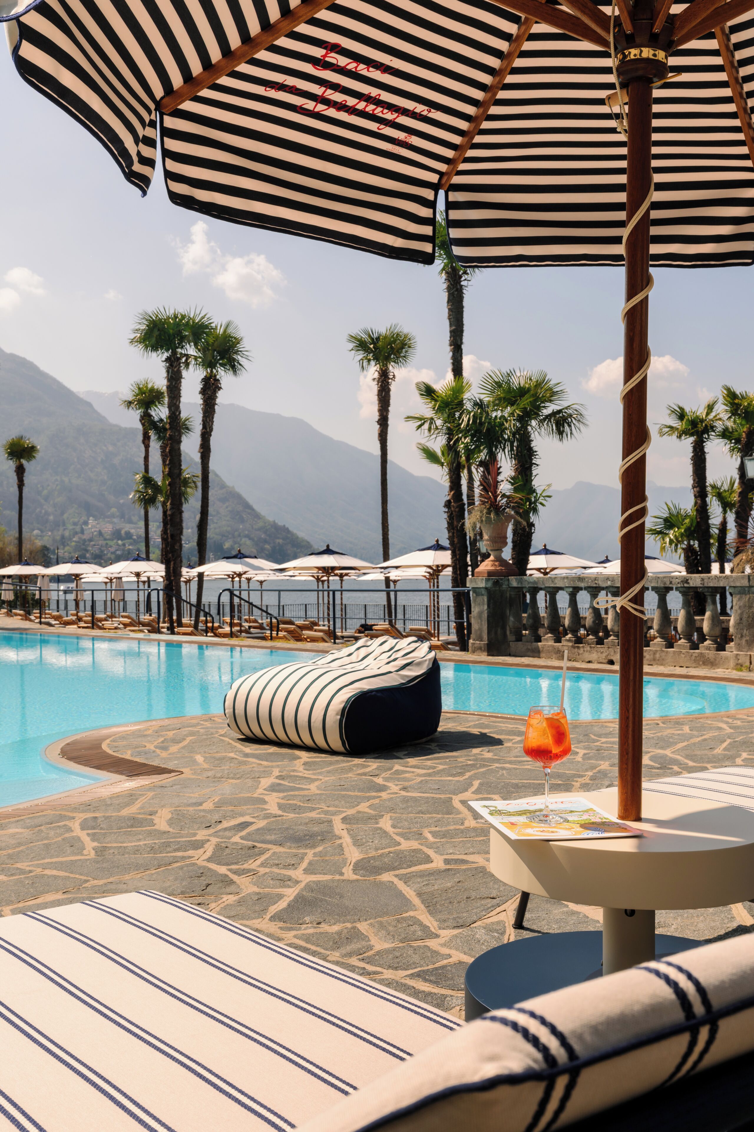Una piscina techada, una piscina al aire libre, sombrillas