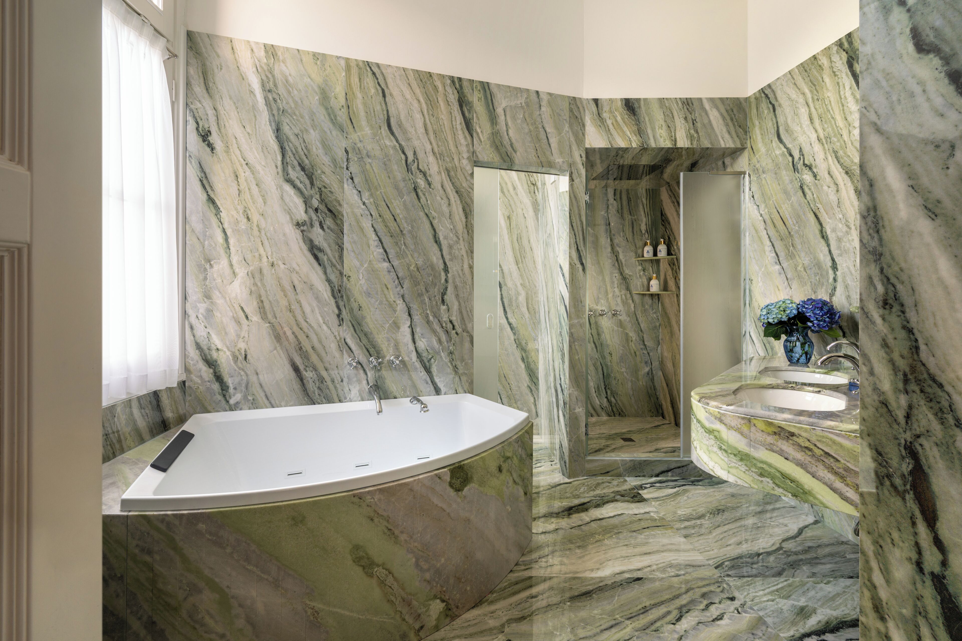 Un baño con bañera independiente, tocador con lavamanos y zona de ducha.
