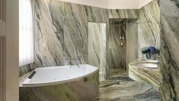 Un baño con bañera independiente, tocador con lavamanos y zona de ducha.