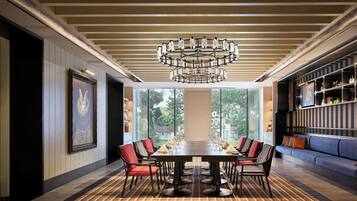 A dining area with a large table, chairs, and a chandelier.