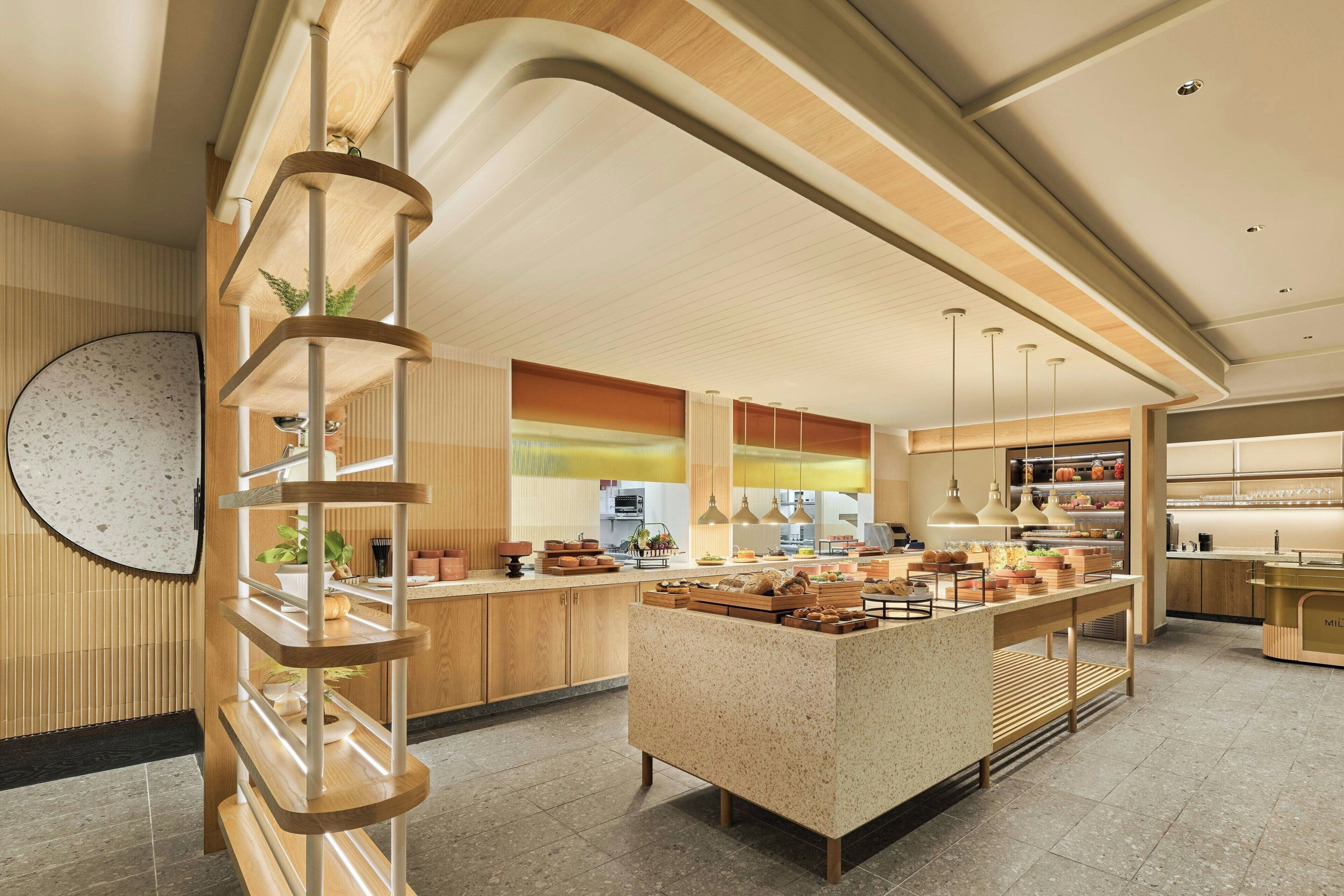 Une cuisine moderne avec des meubles en bois, un îlot central et des luminaires suspendus.