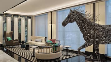 Un vestíbulo moderno con una gran escultura de caballo, una zona de estar circular y una silla de alta gama.