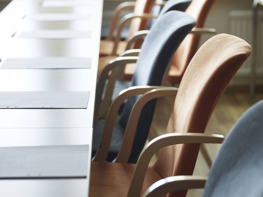 A conference room with a long table and several chairs.