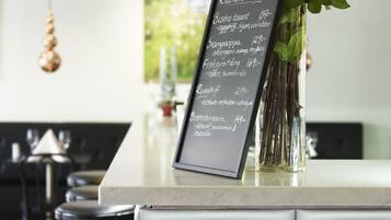 Un panel de menú con un jarrón de rosas rojas y una pizarra que enumera alimentos y precios.