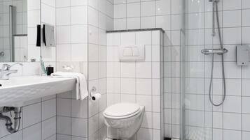 A modern bathroom with a white sink, toilet, and shower.