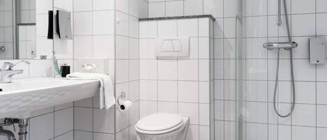 A modern bathroom with a white sink, toilet, and shower.