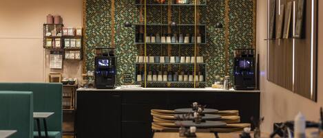 Un café moderno con mostrador, zona de estar y paneles decorativos en la pared.