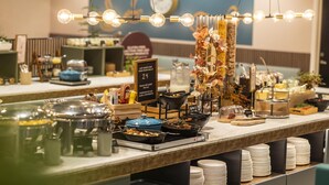 A buffet setup with various food items and a sign indicating a 24-hour food waste goal. - Scandic Aalborg City (Aalborg)