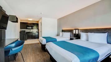 Espacio para trabajar con laptop, ropa de cama y despertador