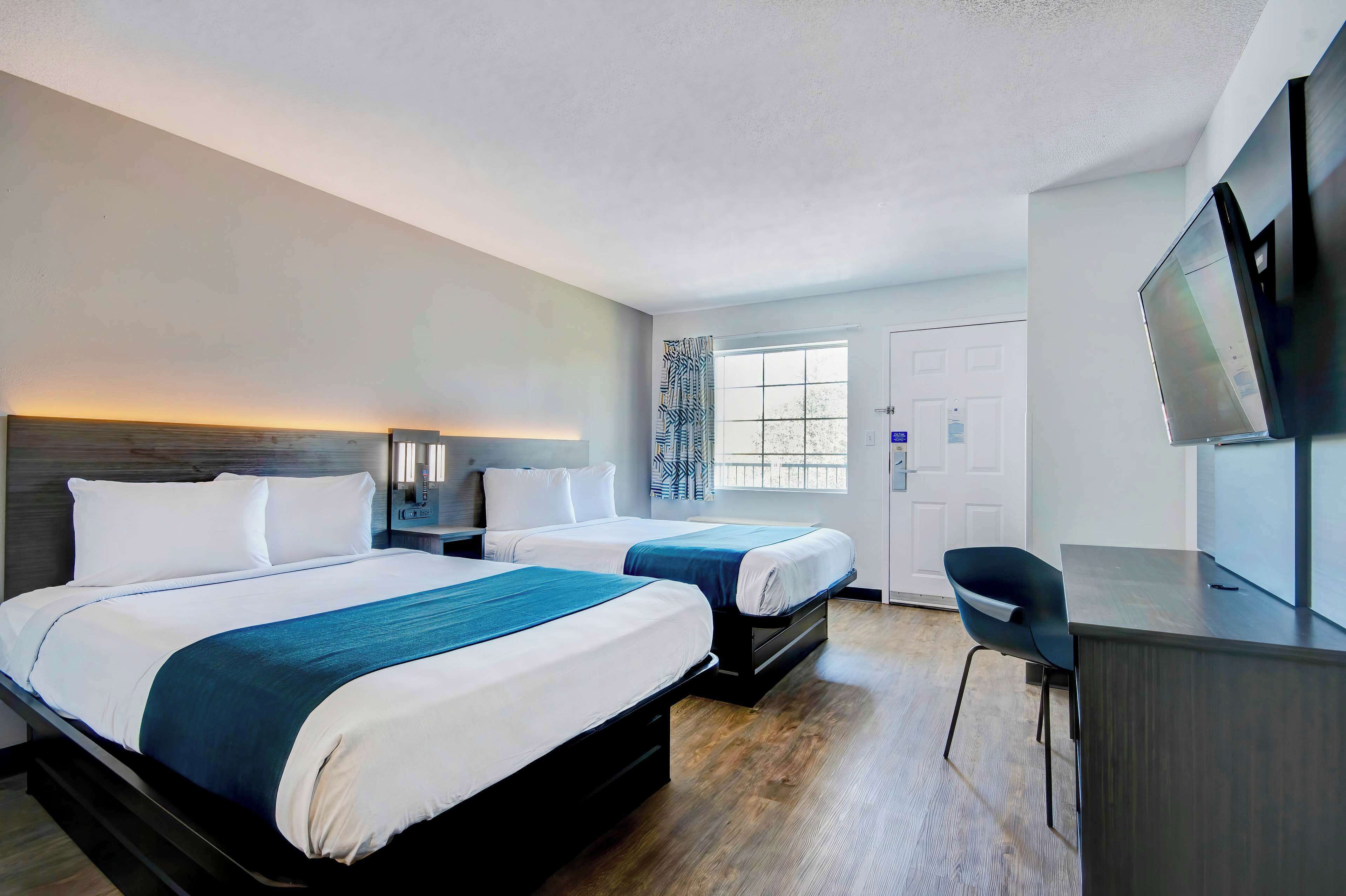 Desk, laptop workspace, alarm clocks, bed sheets
