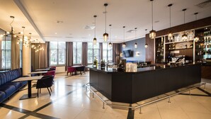 A modern bar area with a counter, seating, and a television screen. - Radisson Blu Hotel, Wroclaw (Wroclaw)