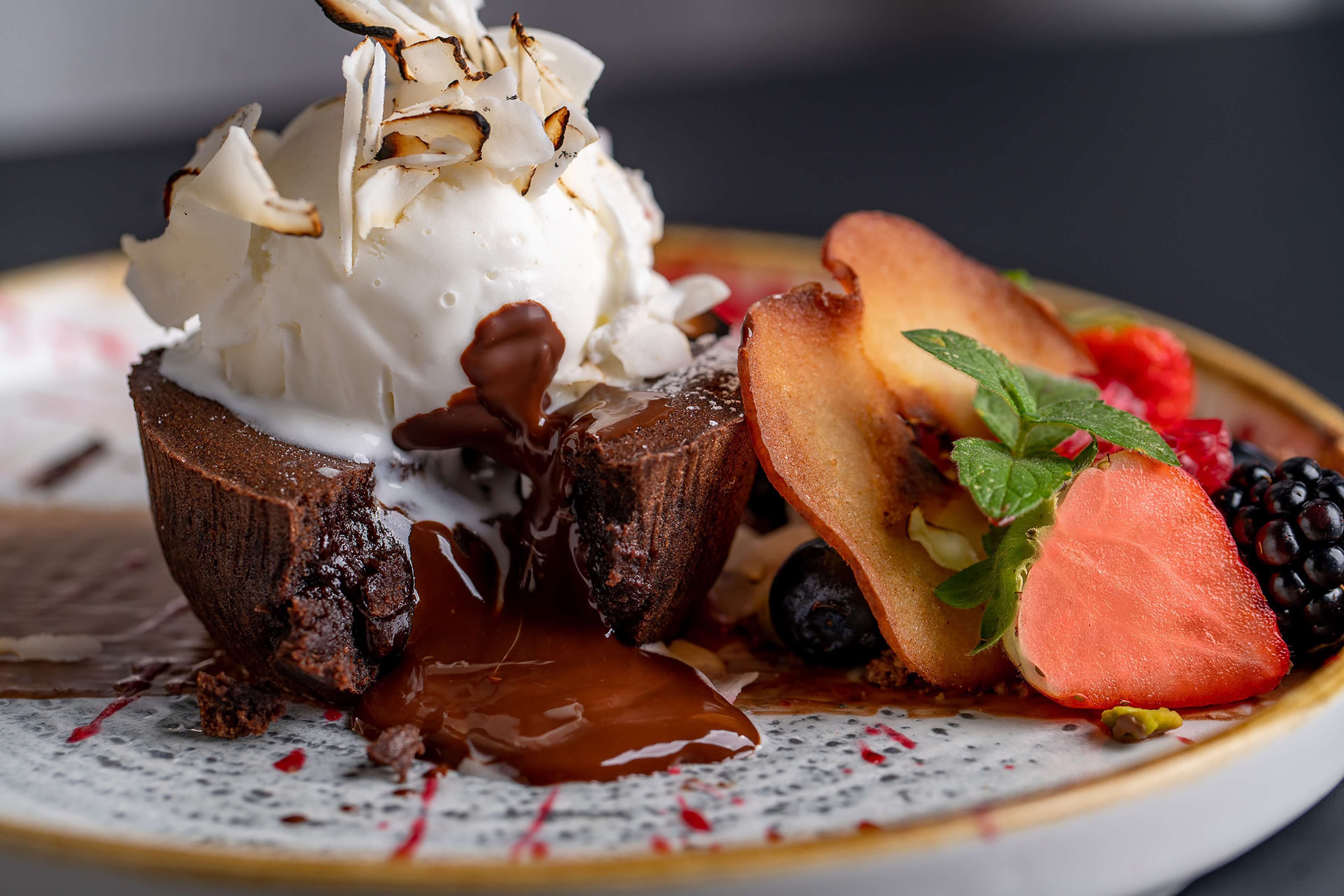 Ein Dessertteller mit Schokoladenkuchen, Eis und frischen Früchten.