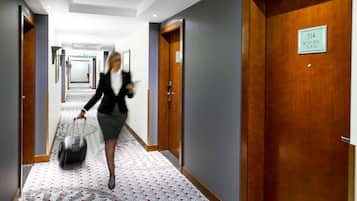 A hotel corridor with doors, a sign indicating room number 514, and a person with luggage.