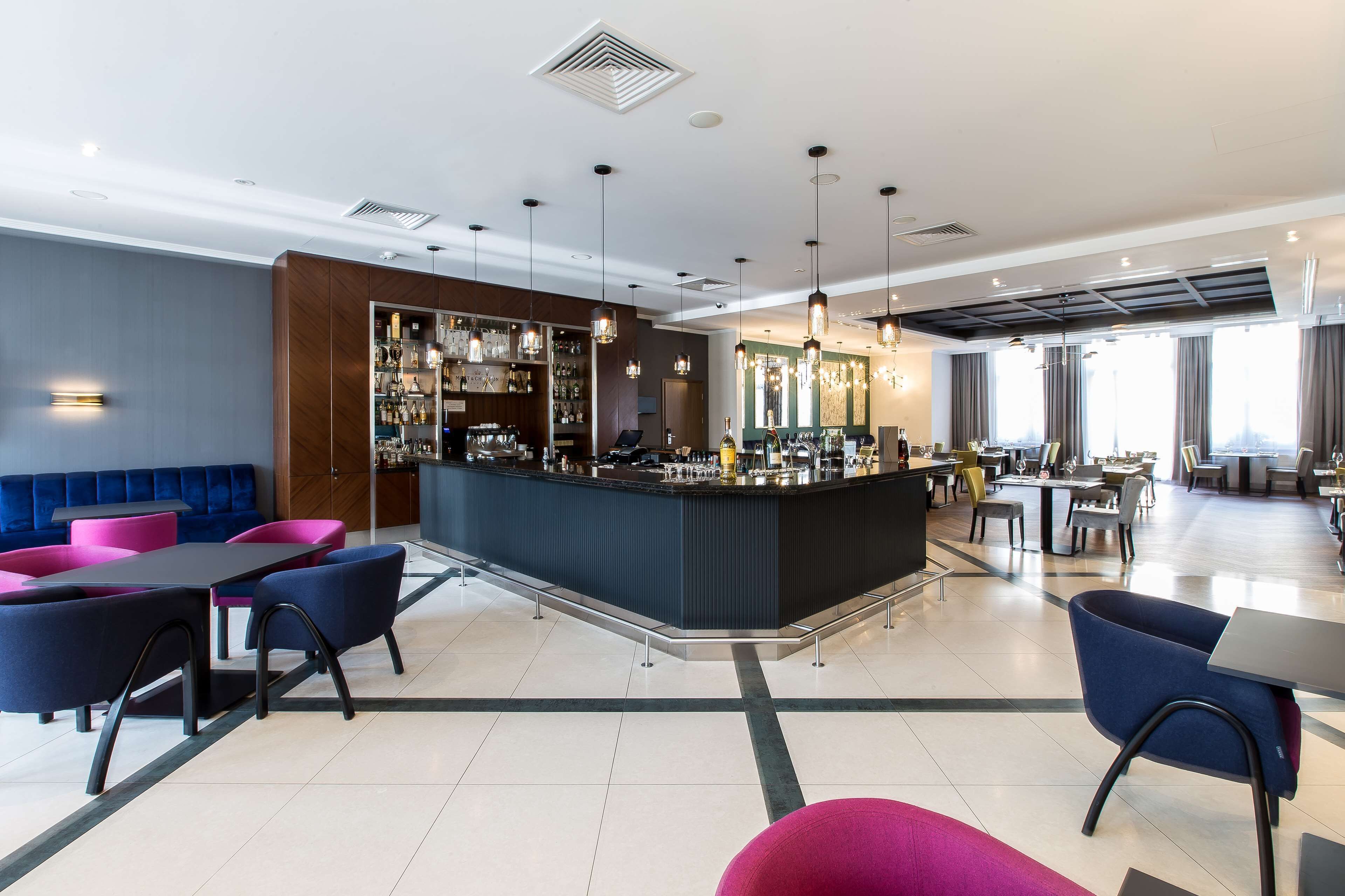 A modern bar area with seating and a counter.
