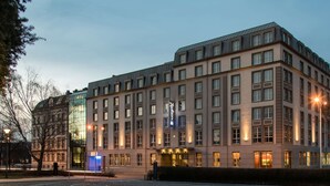 A multi-story hotel with a modern design, featuring a prominent entrance with illuminated signage. - Radisson Blu Hotel, Wroclaw (Wroclaw)