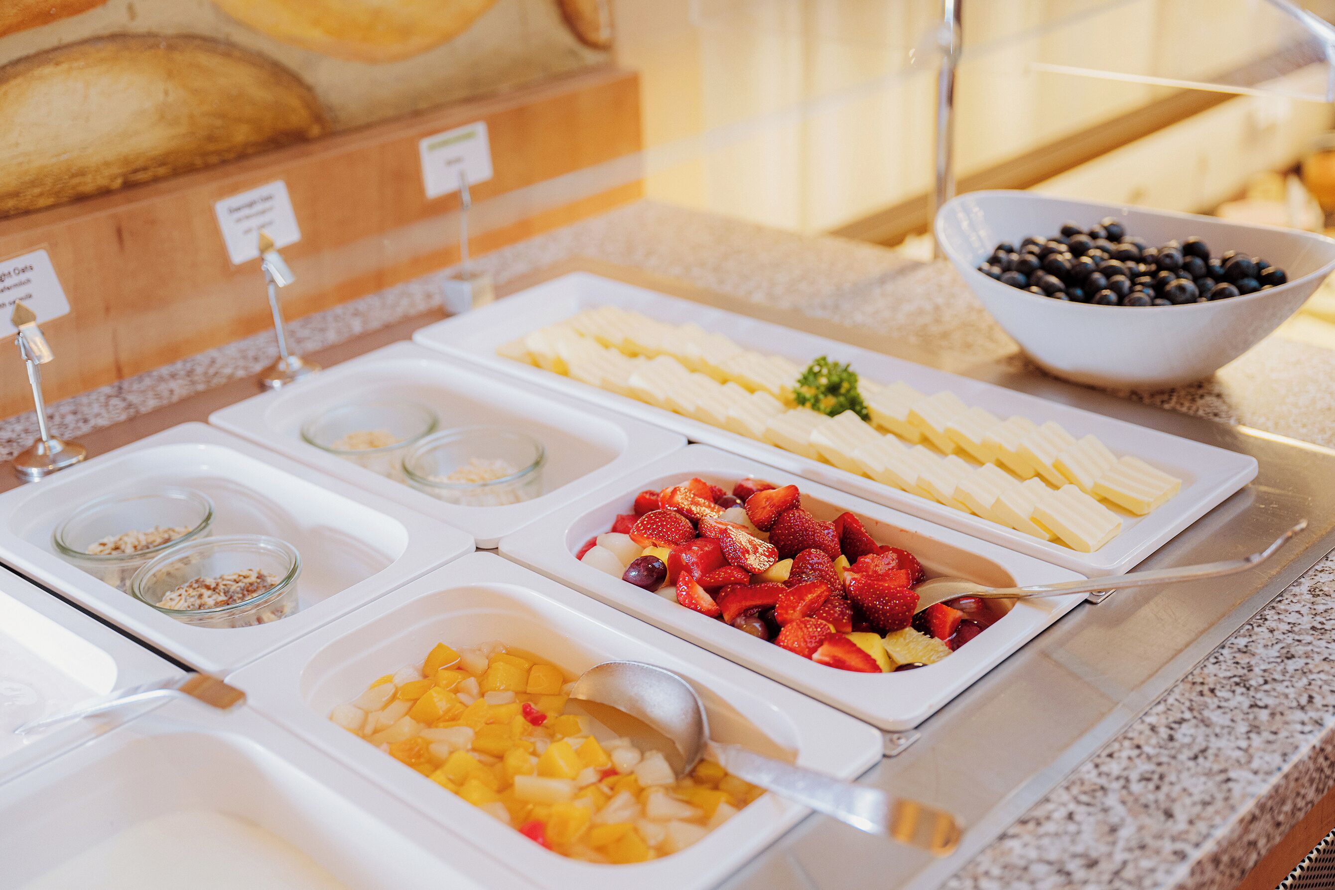 Un buffet con diverse opzioni tra cui frutta, yogurt e cereali.