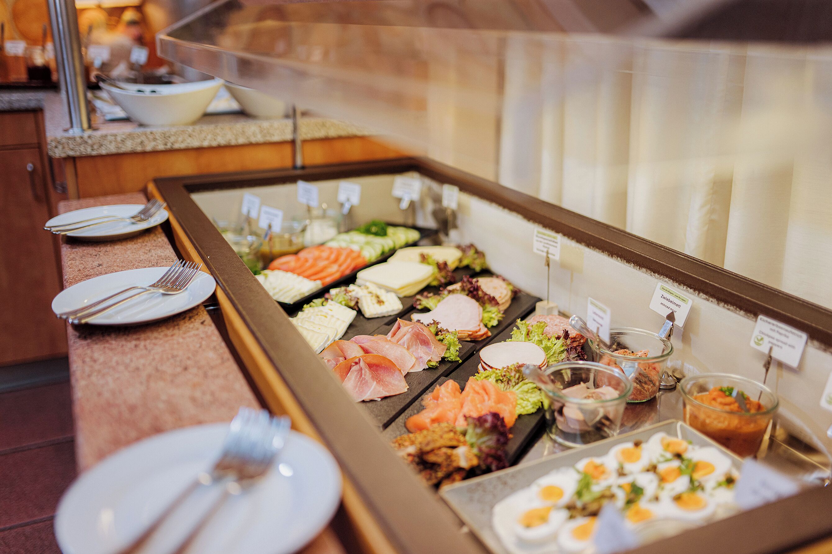 A buffet with various food items and utensils.