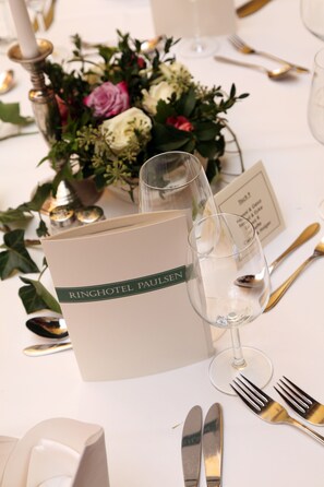 A table setting with a menu card, wine glass, and cutlery. - Ringhotel Paulsen (Zeven)