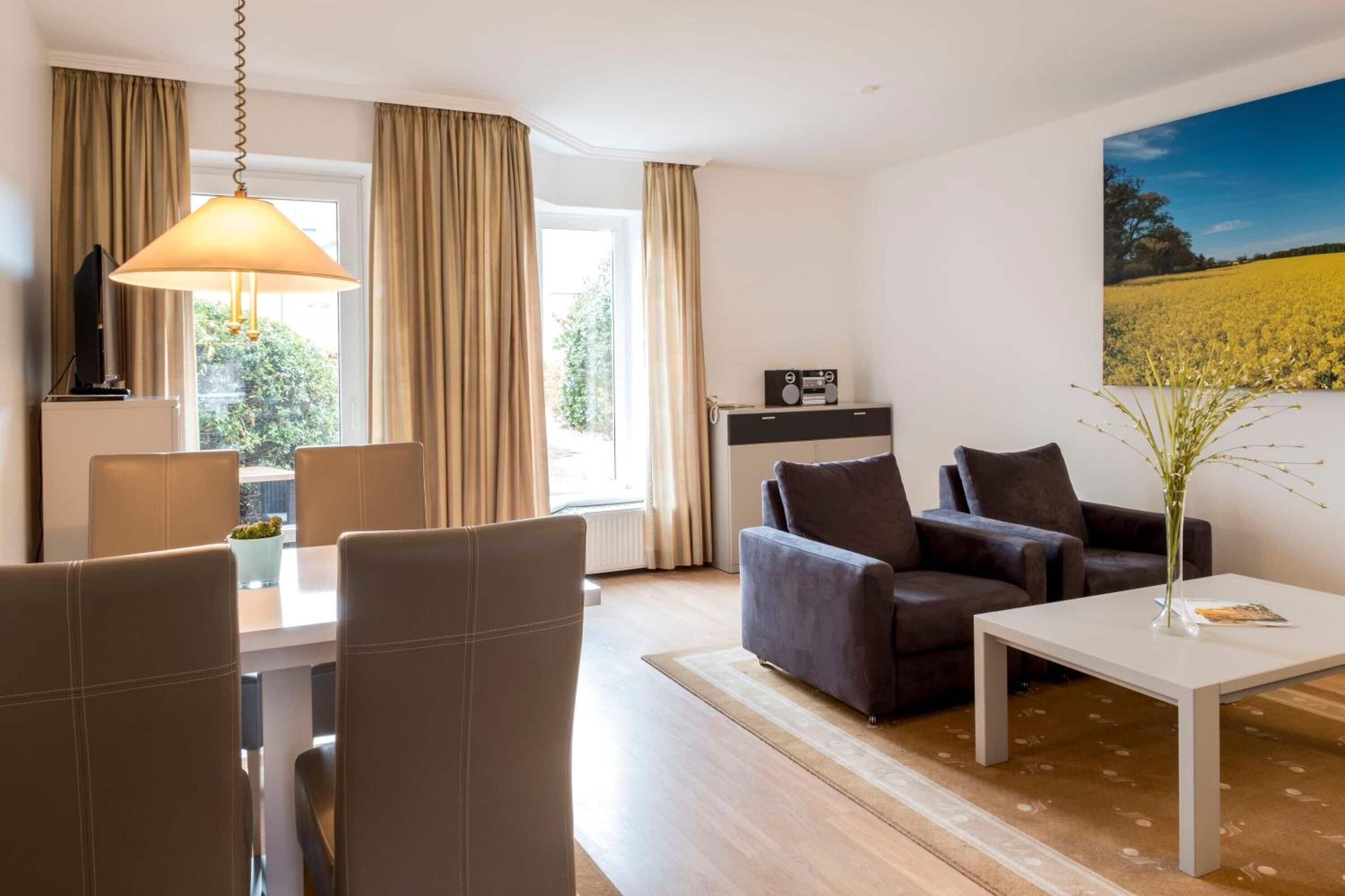 Ein modernes Wohnzimmer mit einer Couch, einem Couchtisch und einem Essbereich mit Stühlen und einem Tisch.