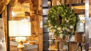 Una habitación acogedora con detalles de madera, una lámpara, una estantería con adornos y una guirnalda con luces.