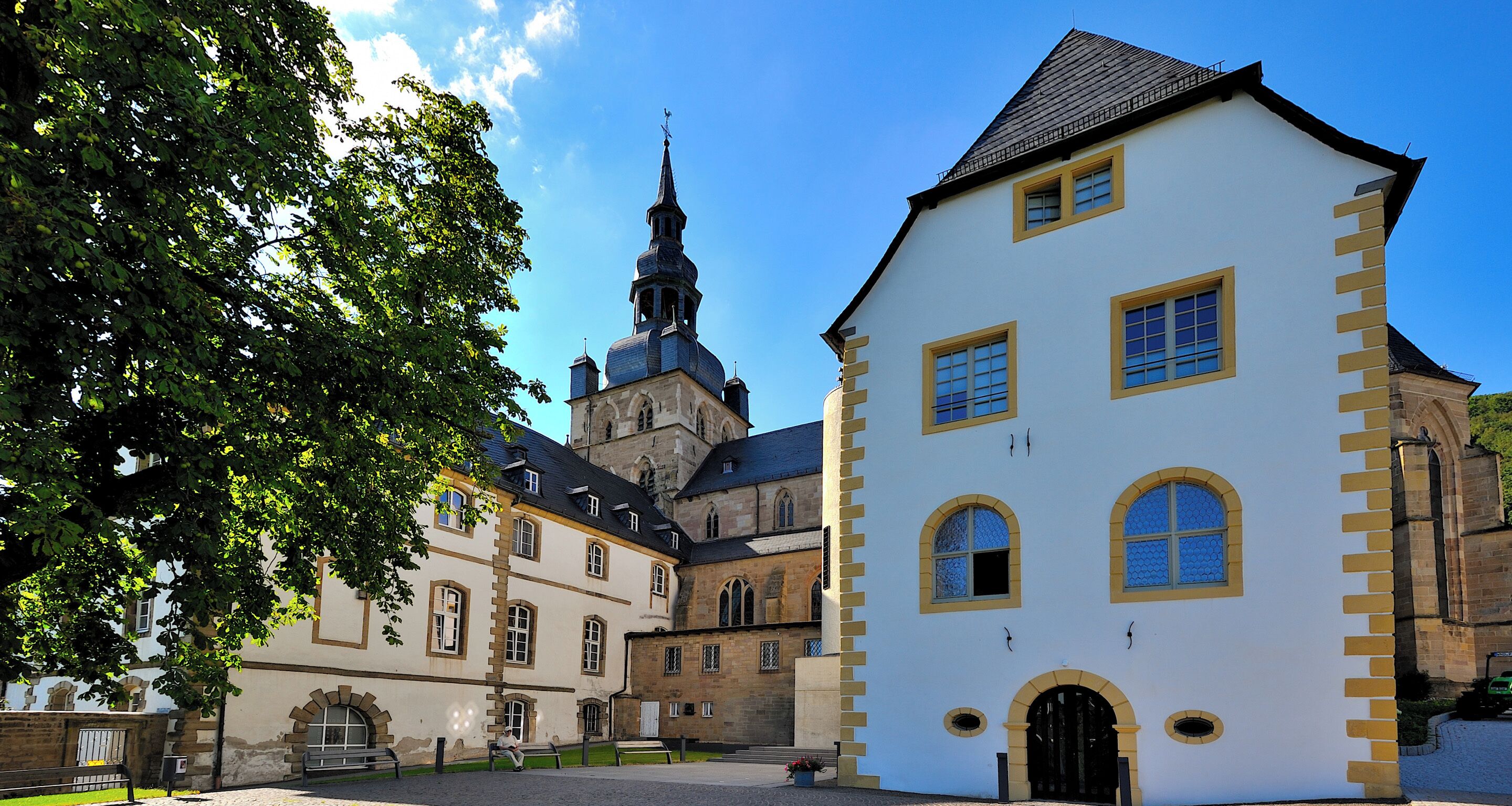 A historic building with a prominent tower, a courtyard, and a well-maintained facade.