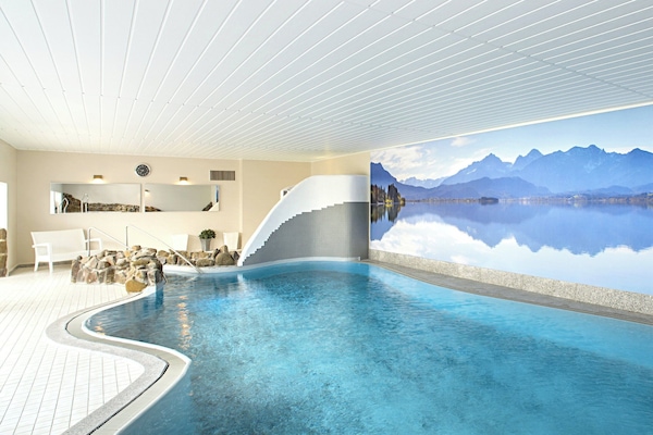 Una piscina techada, sillones reclinables de piscina