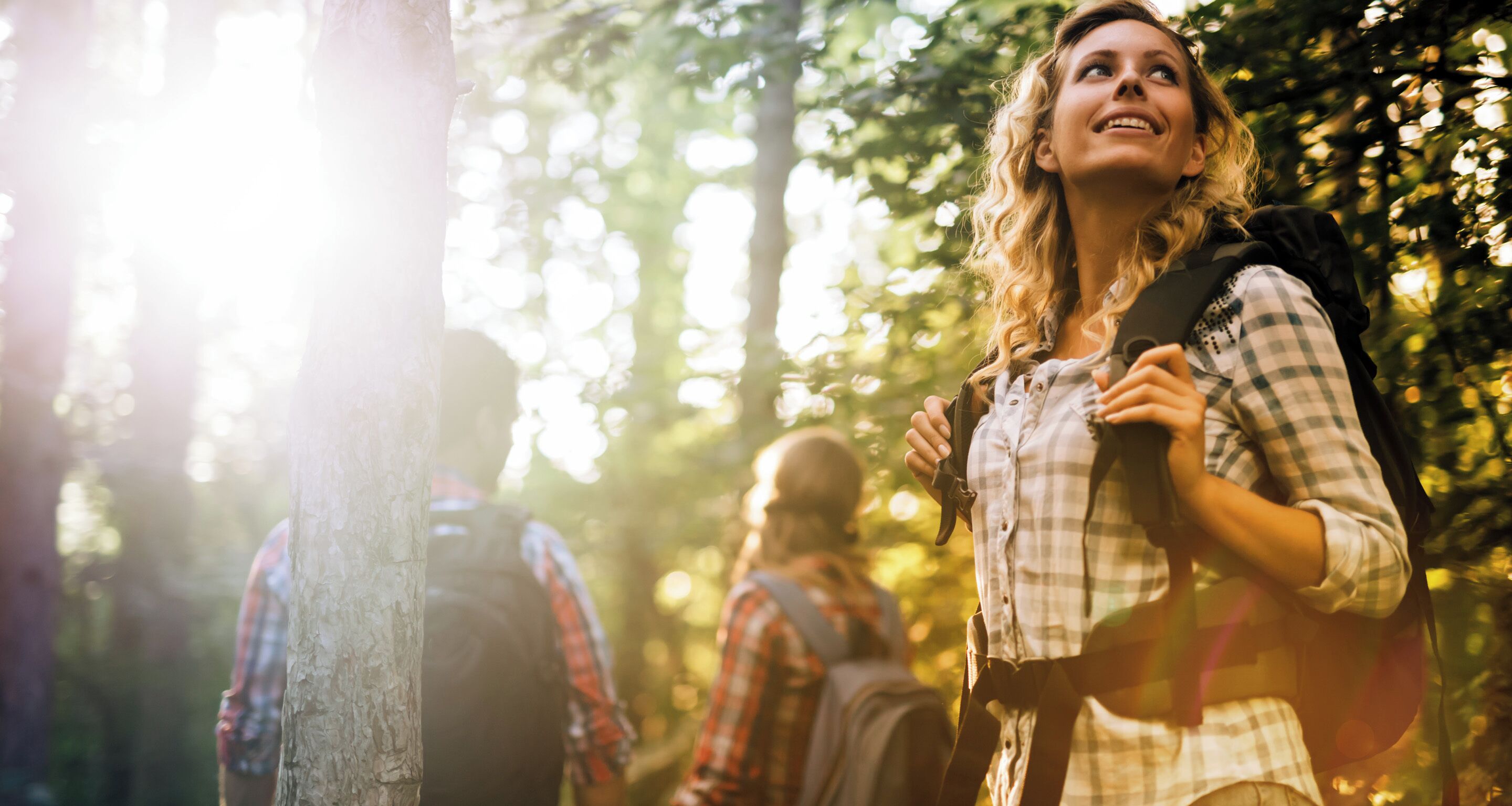 A person with a backpack standing in a forested area.