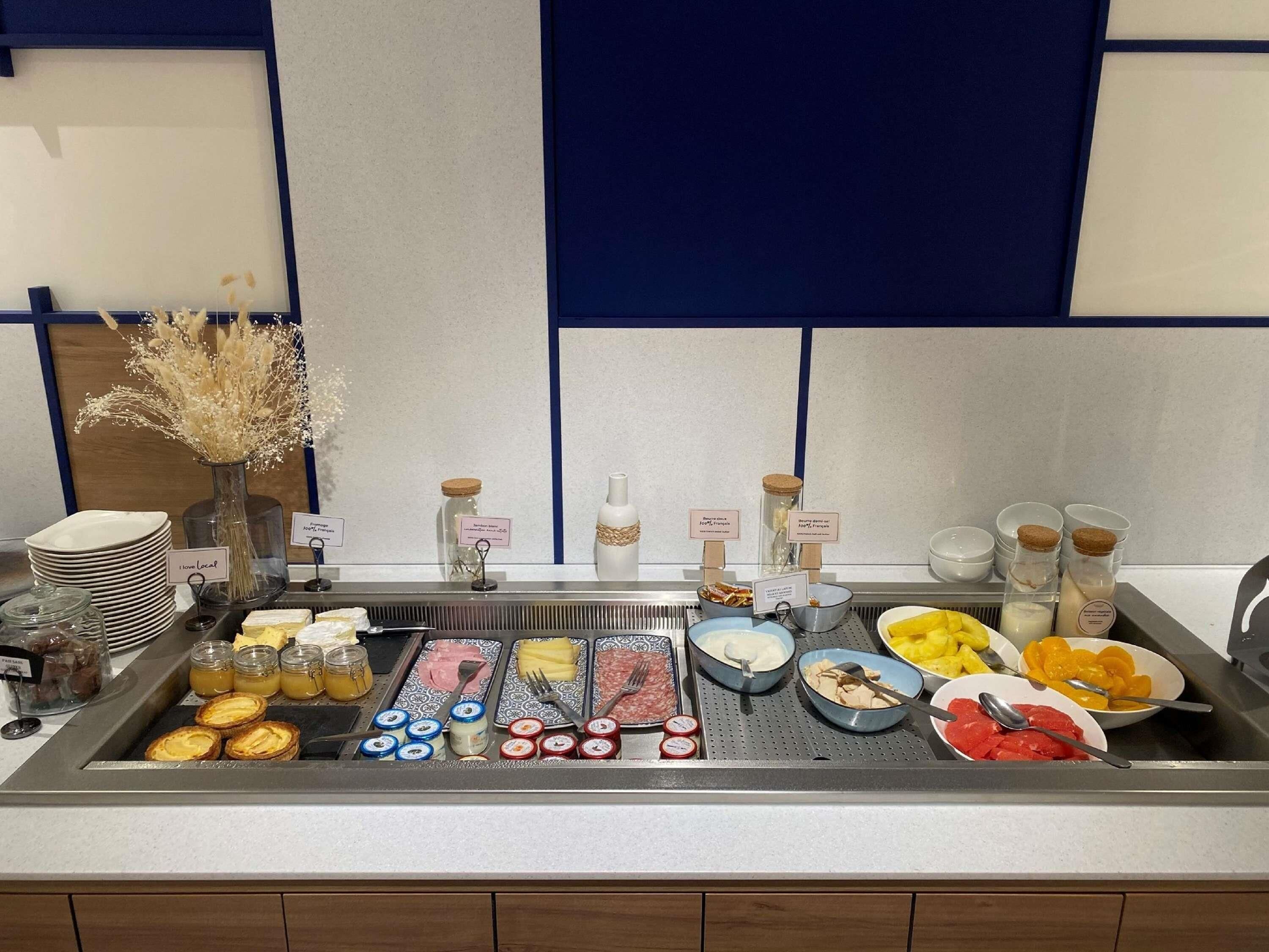 A buffet setup with various food items and condiments.