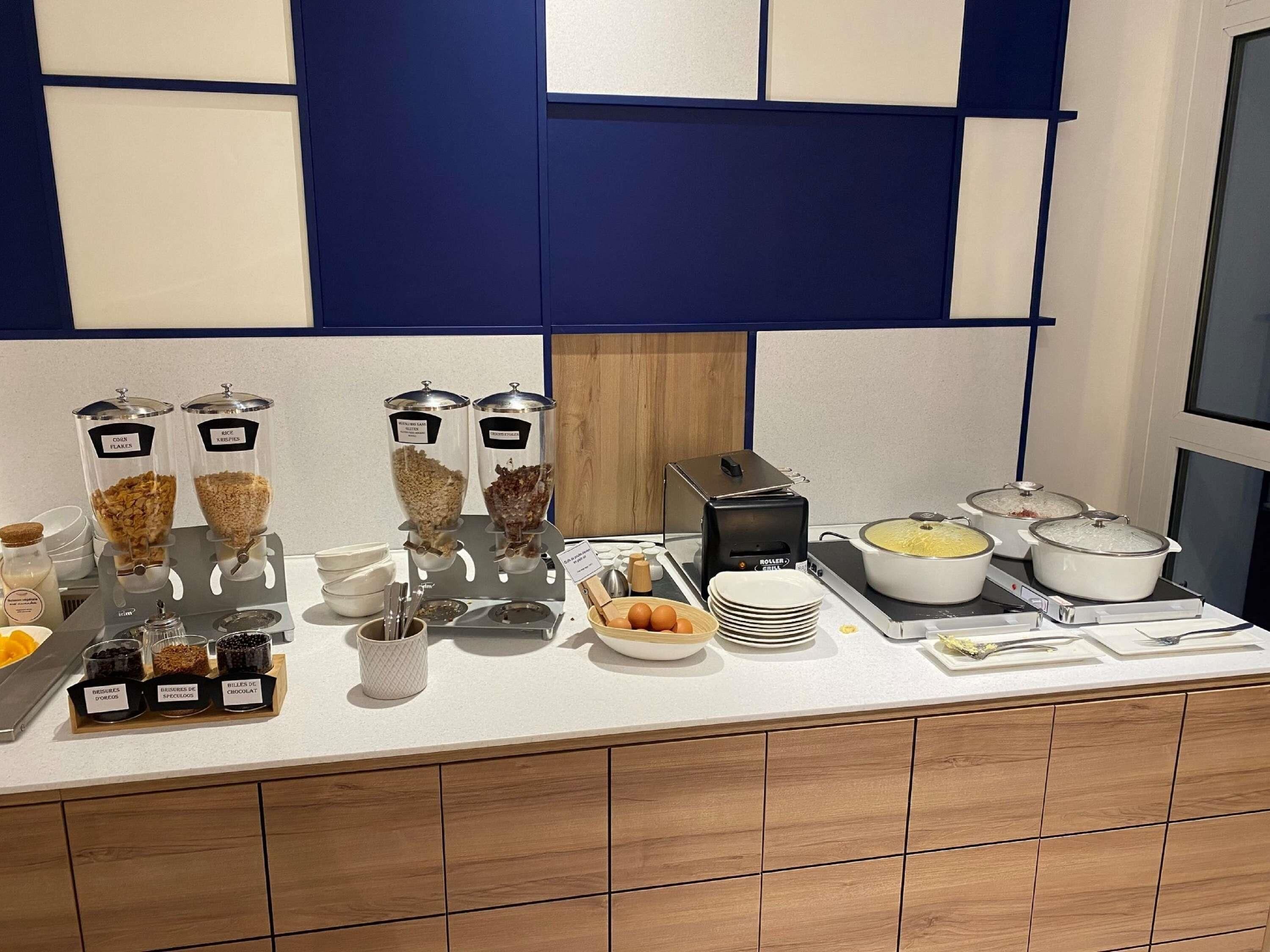 Montaje de bufé con diferentes dispensadores de comida, platos y fuentes calientes.