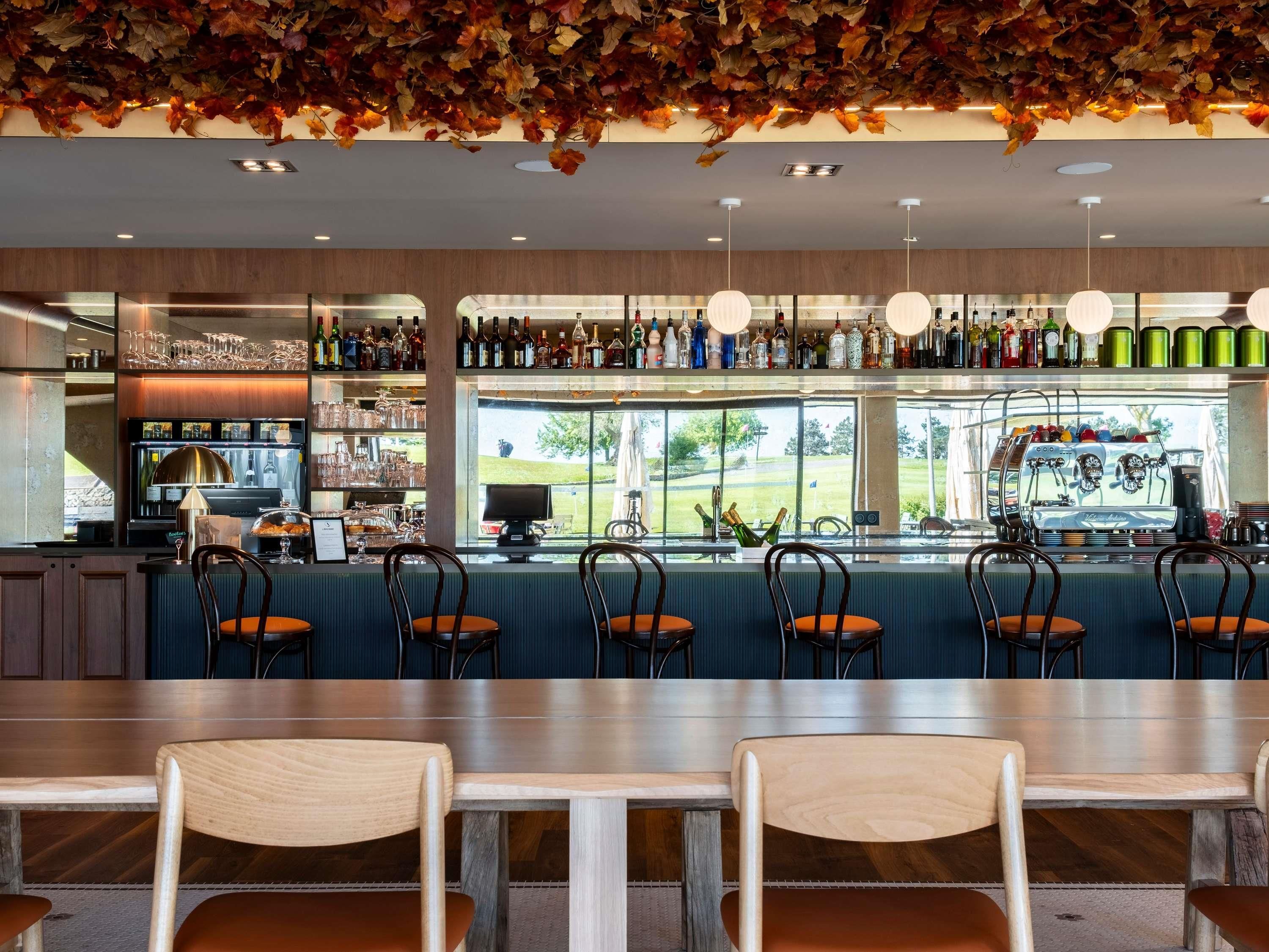 Un área de bar con asientos, una máquina de café y vistas al exterior.