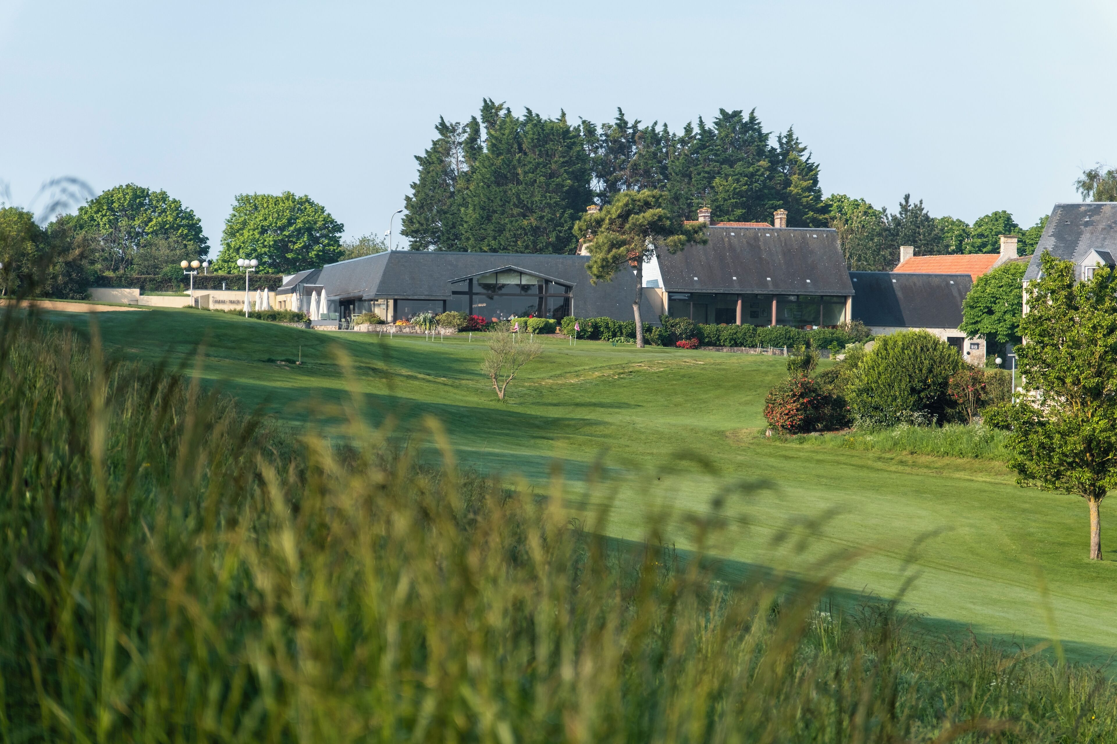 Camp de golf amb un club i edificis residencials al fons.